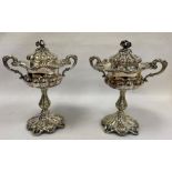Pair of silver plated two handled lidded pedestal bowls, flower finials, scroll decorated, semi