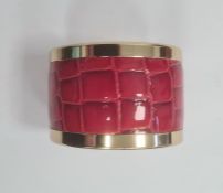 Aspinal of London gilt-coloured bangle set with red faux-snakeskin, marked to bangle, with guarantee