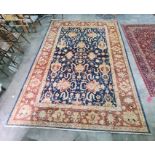 Modern blue ground rug with scrolling foliate design to the central field, stepped border, 373 x