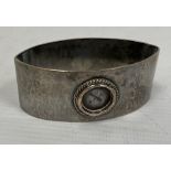 A Liberty & Co silver napkin ring, oval navette form, hammered detail (circular enamel missing),