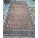 Eastern rug repeated hook medallion to a central red ground field, stepped border, 473 x 238cm