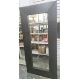 Large modern full length wall mirror of rectangular form within thick black stained wooden frame,