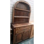Reproduction oak dresser by M&T Limited, London, with arched plate rack, over a base fitted with two