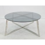 Circular coffee table with smoked glass top, chrome X-shaped base