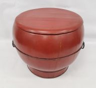 Red lacquered Chinese rice box of ogee form, thin iron banding and iron handles, 38cm high