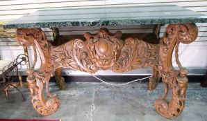 Continental walnut and marble side table, the base profusely carved with cherubs, flowers and swags,