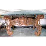 Continental walnut and marble side table, the base profusely carved with cherubs, flowers and swags,