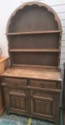 Reproduction oak dresser with arched plate rack, over a base of two drawers and cupboards with