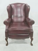 Modern red leather wing back reclining chair on cabriole front legs