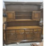 20th century dresser, the moulded cornice above assorted open shelves, cupboard doors, the base of