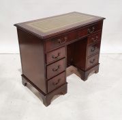 Reproduction kneehole desk with green leather inset top, mahogany body, eight assorted drawers and