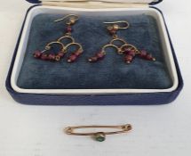 Pair of gold-coloured drop earrings hung with garnet beads and a bar-brooch set with green paste