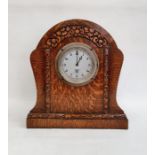 Mid 20th century Smiths oak timepiece, the arched case stylised flowerhead carved on plinth base,