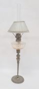 Brass and glass oil lamp having cut well, glass panelled shade, on brass mask and tapering column,