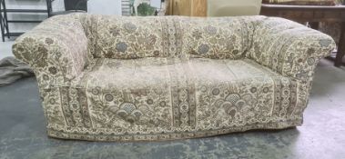 Victorian Chesterfield-type upholstered sofa with loose fitting covers, turned legs, modern roller