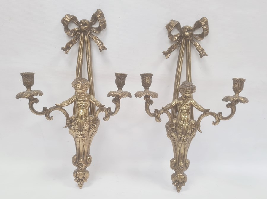 Pair of brass wall-mounted candle holders, each ribbon and putto decorated, 56cm high (2)