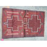 Eastern rug, red ground with two central medallions in reds, blacks, oranges and creams, 130 x 85cm