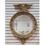 20th century circular mirror in gilt-effect frame surmounted by eagle, 68cm x 45.5cm