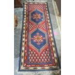 Modern Eastern-style runner with two central medallions on a red ground, stepped border, 210cm x