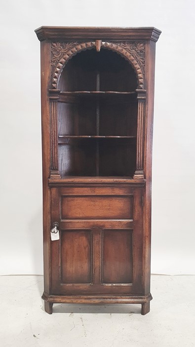 Oak corner unit, the ogee moulded top above three shelves and cupboard door below