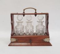 Miniature tantalus, the oak frame with silver plated mounts and handle and fitted with three cut