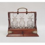 Miniature tantalus, the oak frame with silver plated mounts and handle and fitted with three cut