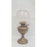 Brass and glass oil lamp with scroll decorated well, on circular foot and the etched bulbous shade