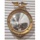 Modern convex wall mirror with gilt-effect finish, surmounted by eagle