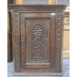 Probably 18th century wall-hanging corner cupboard with carved decoration to the door, 83cm high