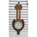 Oak aneroid barometer with scroll pediment, the enamel dial with thermometer, 82cm long overall