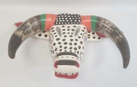 Mexican carved and painted wood ox mask in black, white, orange and green with spots