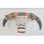 Mexican carved and painted wood ox mask in black, white, orange and green with spots