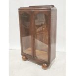 20th century oak display cabinet with two glazed doors enclosing shelves, on bulbous ball feet, 68.