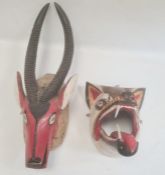 Mexican carved and painted wood antelope mask with large horns, painted in red and black and another