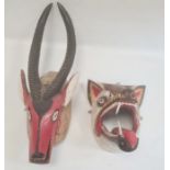 Mexican carved and painted wood antelope mask with large horns, painted in red and black and another