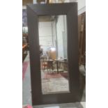 Large modern full length wall mirror of rectangular form within thick black stained wooden frame,