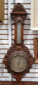 Victorian carved walnut aneroid barometer with carved arched pediment, thermometer above the dial