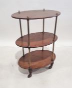 Late 19th/early 20th century three tier trolley, the shelves in oval mahogany united by brass