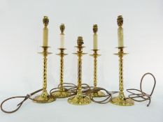Five brass table lamps with twisted column, on circular foot, four have faux-candle fittings, 29cm