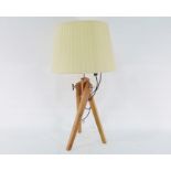 Table lamp formed as a wooden tripod with adjustable legs