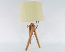 Table lamp formed as a wooden tripod with adjustable legs