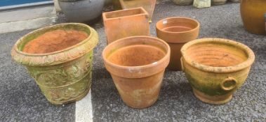 Collection of terracotta garden pots, two with moulded relief, one tapered rectangular and two