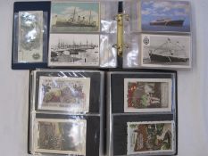 Two albums of mainly early to mid 20th century postcards, including Christmas and New Year street