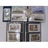 Two albums of mainly early to mid 20th century postcards, including Christmas and New Year street