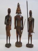 Carved Tanzanian warrior with spear, 54cm high and a pair of male and female Tanzanian figures