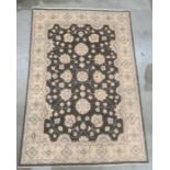 Modern Eastern-style black ground rug, the central field with foliate decoration, on a cream