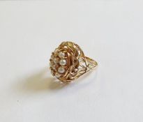 Gold-coloured swivel ring, the centre with oval coral cabochon, seedpearl and diamond option, within