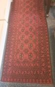 Modern red ground rug with repeating central medallions, in reds, blacks and whites, 296cm x 80cm