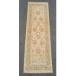 Modern Eastern-style cream ground runner with foliate decoration and border, 246cm x 80cm