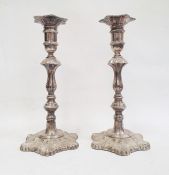 Pair of 1970's silver-mounted candlesticks with relief decoration, on quatrefoil-shaped bases and